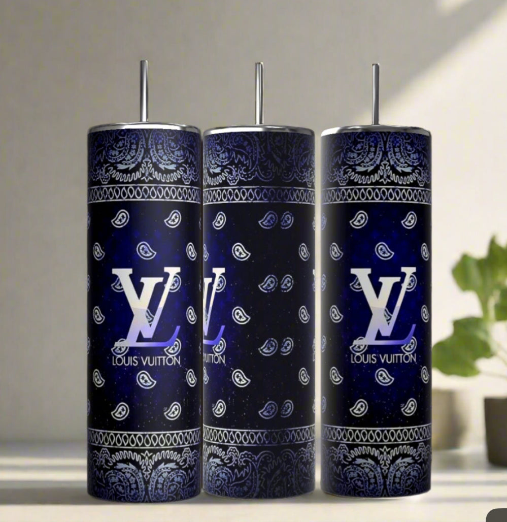 Three Louis Vuitton Blue Ombre 20oz Tumblers by Kreative Kreationz, each with a metal straw and decorated in a blue and black paisley bandana pattern with large white logos, are displayed on a light surface next to a small green plant.