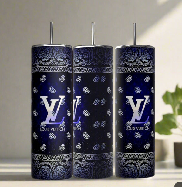 Three Louis Vuitton Blue Ombre 20oz Tumblers by Kreative Kreationz, each with a metal straw and decorated in a blue and black paisley bandana pattern with large white logos, are displayed on a light surface next to a small green plant.