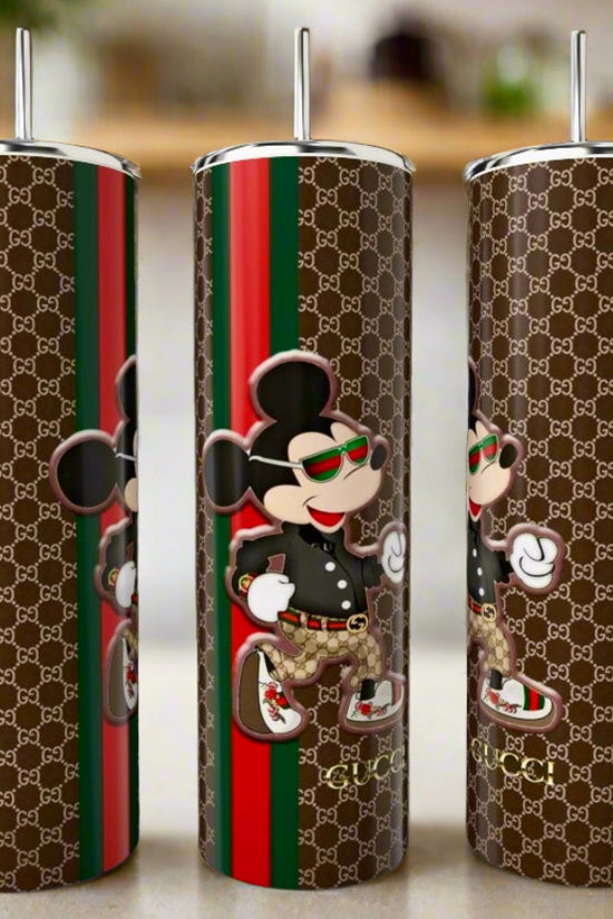 The Mickey Mouse GUCCI 20oz Skinny Tumbler by Kreative Kreationz features a brown Gucci-inspired pattern, red-green stripes, and a stylish cartoon mouse—perfect luxury drinkware for any trendsetter.
