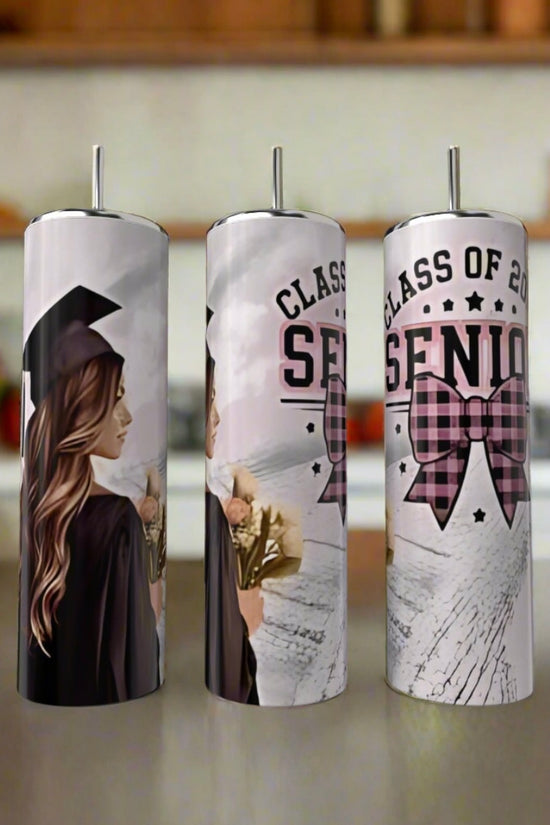 Three Kreative Kreationz 2025 Graduate 20oz Tumblers with lids and straws sit on a counter, featuring a cap-and-gown grad, “Class of 2025 Senior,” a pink plaid bow, and an eco-friendly design. Perfect gift for the graduating senior!.