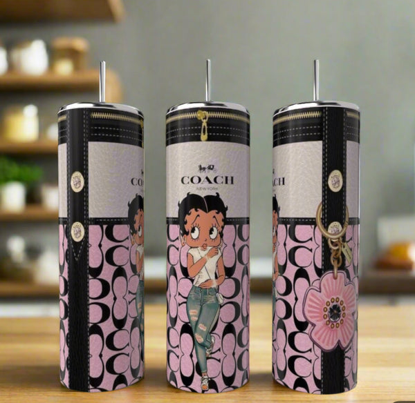 Three Kreative Kreationz "Betty B Pink Coach Zip" 20oz skinny tumblers with straws feature pink and black Coach-inspired patterns, zipper accents, and eco-friendly stainless steel, shown on a wooden surface with a blurred kitchen background.