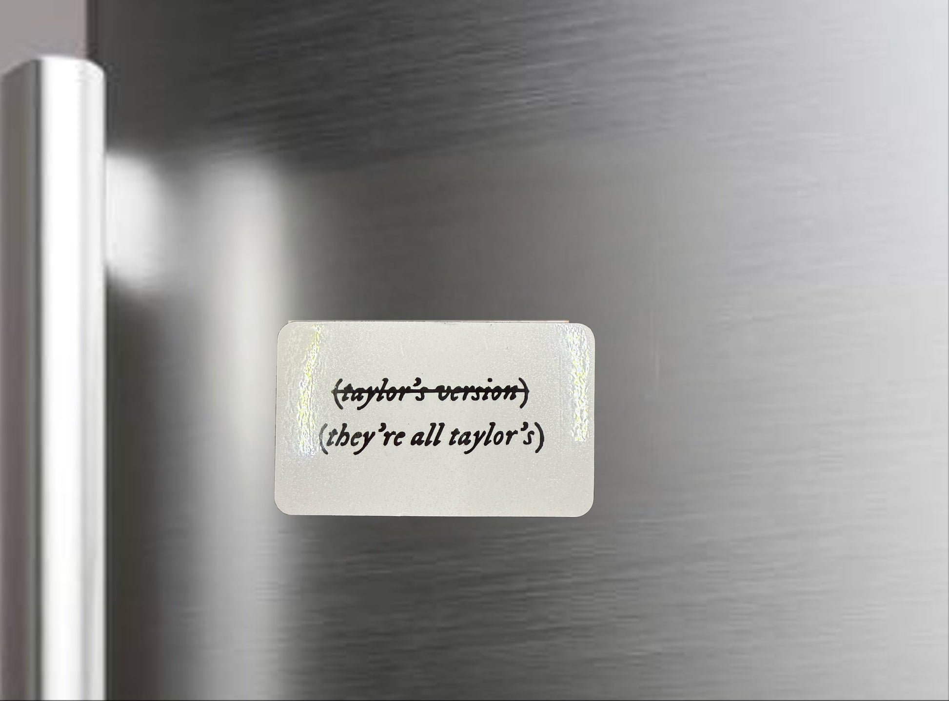 The Kreative Kreationz They’re all “Taylors Version” Fridge Magnet features "(taylor’s version)" and "they’re all taylor’s" on a metallic surface—a fun Swiftie gift and perfect Taylor Swift magnet for fans.