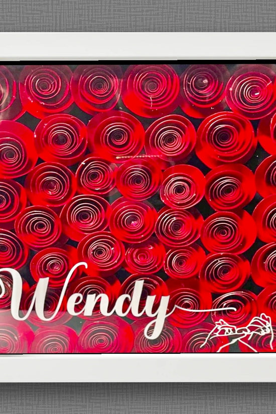The Red Roses Flower Shadow Box | Personalized by Kreative Kreationz features tightly arranged red paper roses in a white frame, with 