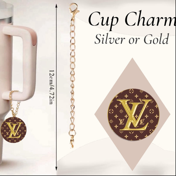 The Louis Vuitton Charm Dangle by Kreative Kreationz is a 12 cm cup accessory with a gold lobster clasp chain and round brown pendant featuring a gold "LV" monogram, available in silver or gold. Shown hanging on a mug.