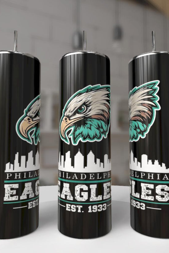 Kreative Kreationz EAGLES - Football 20oz Skinny Tumblers feature a fierce eagle face, city skyline, and “Philadelphia Eagles EST. 1933” in bold white and green. These eco-friendly reusable tumblers are shown indoors on a white surface.