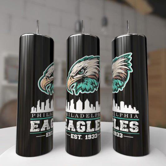 Kreative Kreationz EAGLES - Football 20oz Skinny Tumblers feature a fierce eagle face, city skyline, and “Philadelphia Eagles EST. 1933” in bold white and green. These eco-friendly reusable tumblers are shown indoors on a white surface.