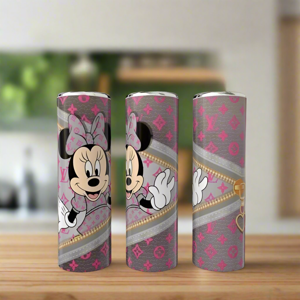 Three 20oz skinny tumblers from Kreative Kreationz’s Mickey Mouse LV Peek-a-Boo Collection, featuring grey and pink patterns, gold zippers, and Minnie Mouse designs, are displayed on wood with a blurred kitchen background.