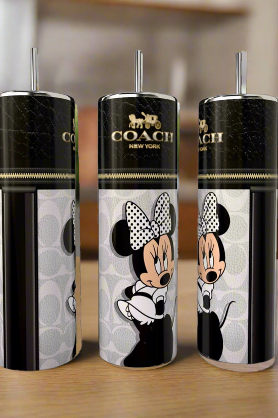 Three Kreative Kreationz Minnie Mouse Coach Series 20oz Skinny Tumblers with black lids and straws show Minnie in a polka-dot bow with the Coach New York logo, displayed on a wooden surface.