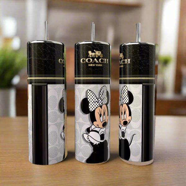 Three Kreative Kreationz Minnie Mouse Coach Series 20oz Skinny Tumblers with black lids and straws show Minnie in a polka-dot bow with the Coach New York logo, displayed on a wooden surface.