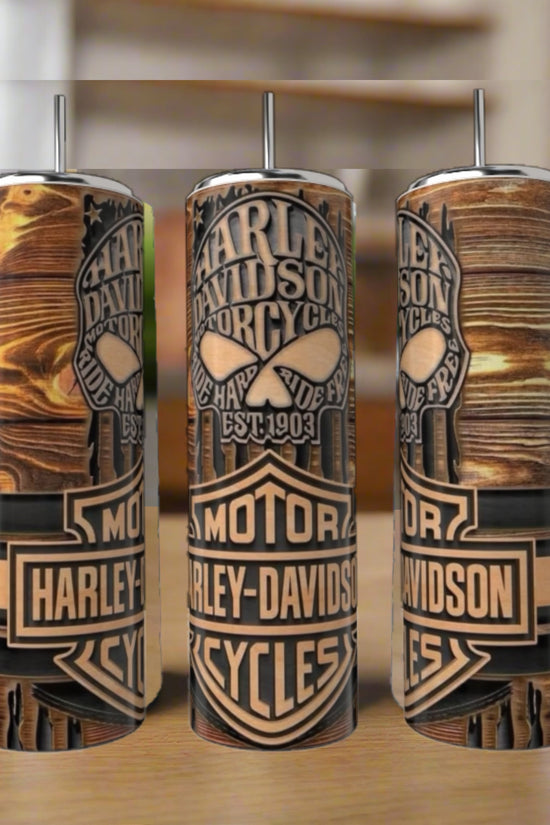 Three Harley Davidson 20oz Skinny Tumblers by Kreative Kreationz, each with double-walled stainless steel, vivid wooden plank designs, and Harley-Davidson logos, sit on a wooden surface against a blurred background.