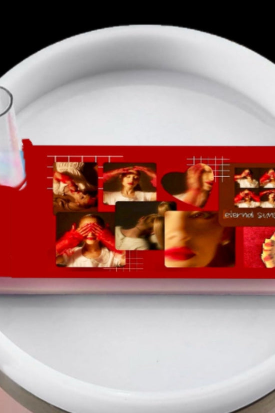 Stanley tumbler with a lid plate/topper, the topper has a red collage of external sunshine Ariana grande with wording in handwriting font of different lyrics 