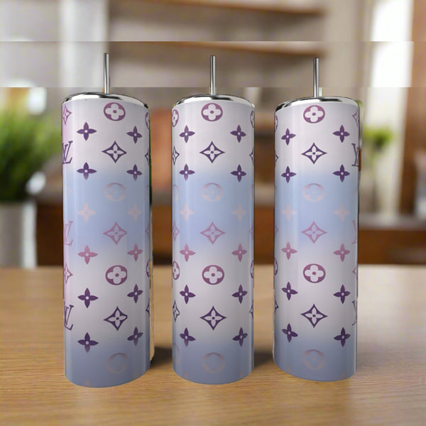 Three LV Pastel Inspired 20oz Tumblers by Kreative Kreationz, featuring gradient pastel blue and purple hues with monogram-style patterns, are displayed on a wooden surface—stylish, eco-friendly drinkware for any setting.