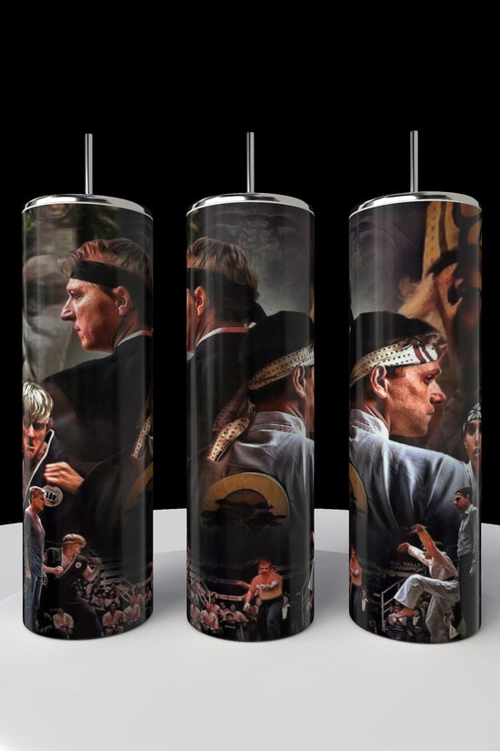 Three Kreative Kreationz Kobra Kai 20oz cylindrical stainless steel tumblers with martial arts scenes and characters in action poses. The imagery pops against a black background on a circular white platform, ideal for any Kobra Kai enthusiast.