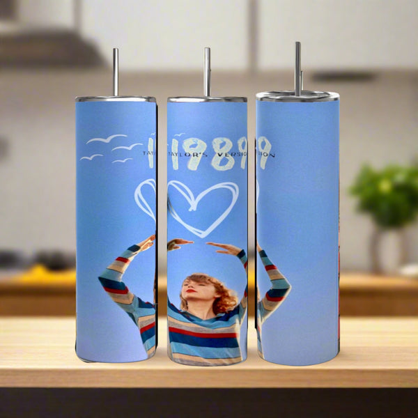 Three Taylor Swift 1989 20oz Tumblers by Kreative Kreationz, crafted from eco-friendly stainless steel, feature metal straws and unique designs: a person in a striped sweater, heart and bird graphics, plus "1989 TAYLOR'S VERSION" text.