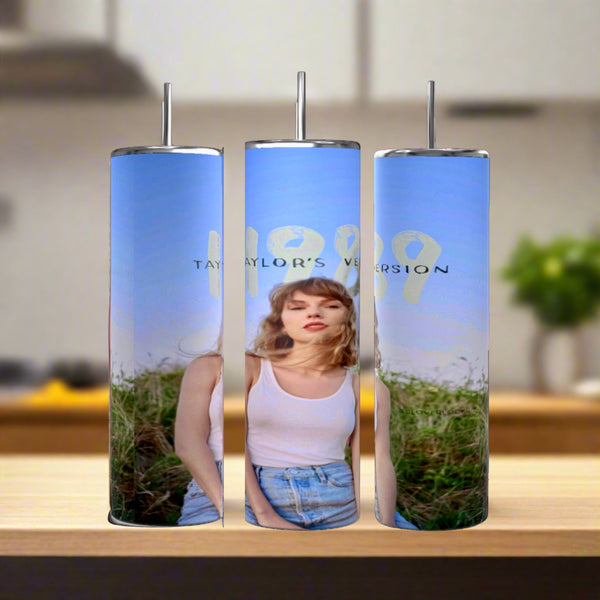 The Taylor Swift 1989 20oz Tumblers by Kreative Kreationz are eco-friendly, reusable and feature a photo of a woman in white tank top and denim shorts under blue skies with “1989 Taylor’s Version” text, each with a stainless steel straw.