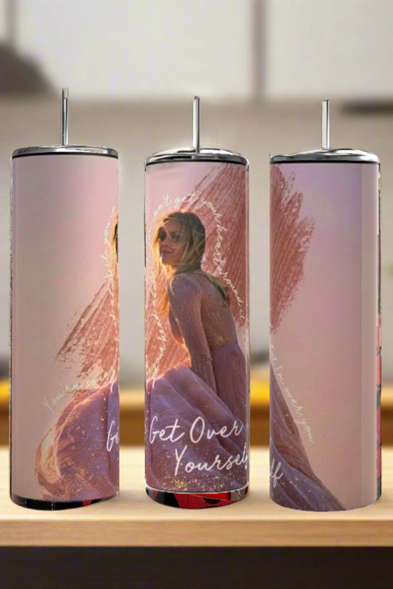 Three Kelsey Ballerini Over Yourself 20oz tumblers by Kreative Kreationz, each with an image of a woman in a pink dress and sunglasses plus “Get Over Yourself” text, sit with metal straws on a wooden surface against a blurred kitchen backdrop.