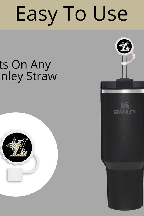 A black Stanley tumbler with a handle is shown, featuring the LV Straw Cover by Kreative Kreationz. The background reads 