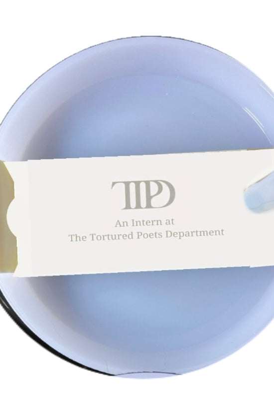 A circular blue ashtray holds an open white matchbox that reads 