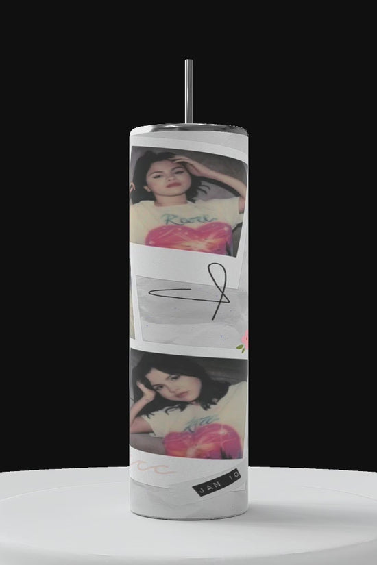 Three tall tumblers are decorated with images of Selena Gomez in different poses; one in a white dress, one with a serious expression, and one in casual attire. The designs, reminiscent of intricate Stanley cups, are embellished with flowers, leaves, hearts, and text like 