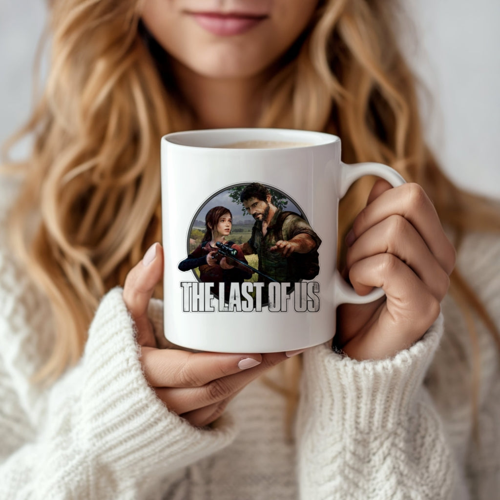 A woman in a white sweater holds the Kreative Kreationz The Last Of Us Ceramic Mug, featuring game characters in a striking photographic design with the title printed below.