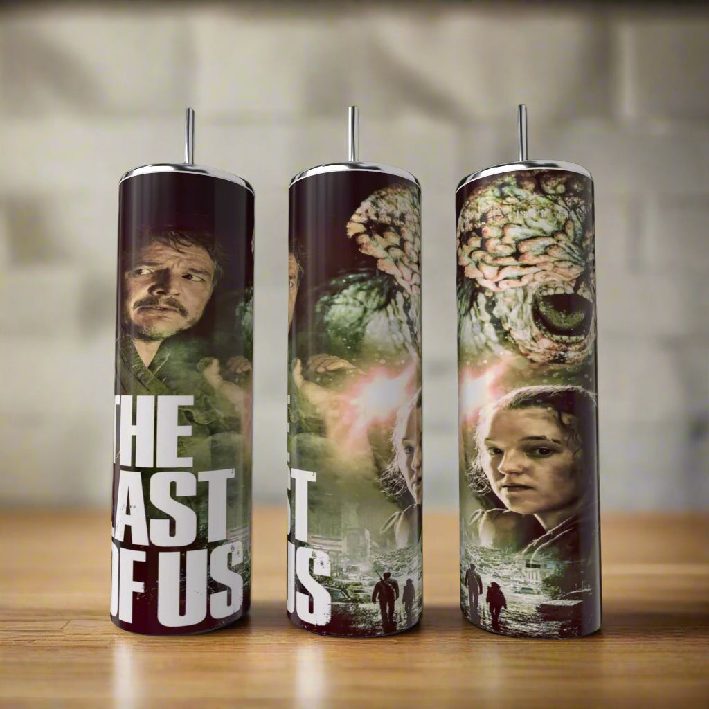 Three tall The Last Of Us Tumblers by Kreative Kreationz, featuring main characters, post-apocalyptic scenes, and a monstrous creature sit on a wooden surface—perfect eco-friendly drinkware for fans of the series.